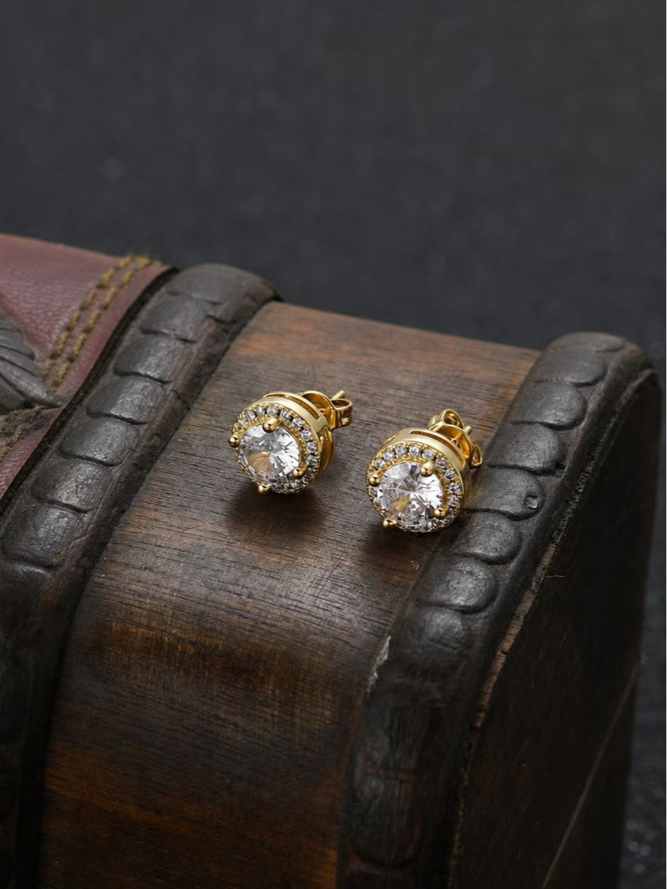 Two gold-plated cubic zirconia halo studs displayed on a rustic wooden box