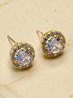 Close-up front view of gold-plated halo stud earrings with round CZ centre on beige surface