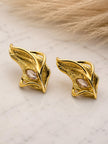 Pair of gold-plated feather stud earrings with marquise crystal centres on marble surface
