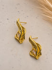 Side view of gold feather stud earrings showing push-back posts on a speckled white surface