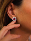 Model wearing a silver double halo ruby red stud earring on her right ear, side profile view