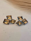 Pair of silver-finish square crystal cluster stud earrings on a white surface with neutral background