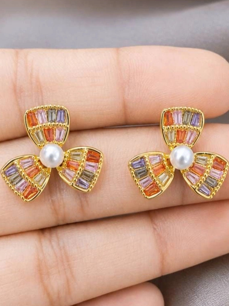 Pair of gold-plated multicolour flower stud earrings held in an open palm showing size and stone colour detail