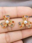 Pair of gold-plated multicolour flower stud earrings held in an open palm showing size and stone colour detail