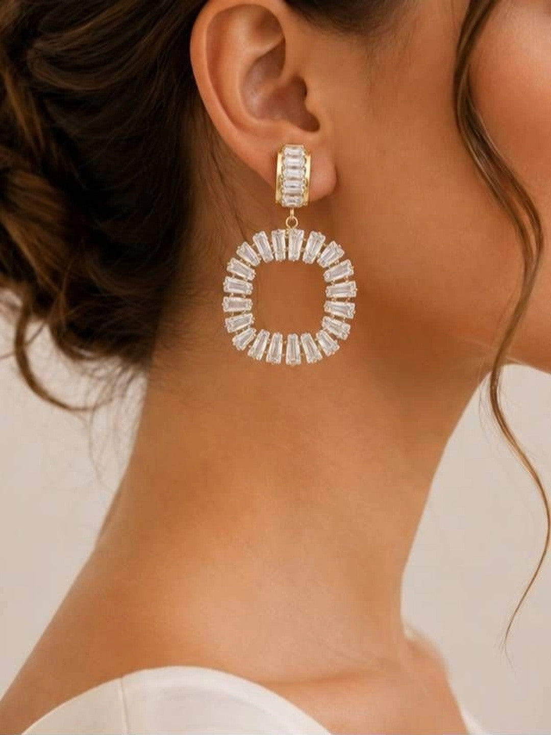 Woman wearing gold-plated circular baguette CZ drop earring with updo hairstyle