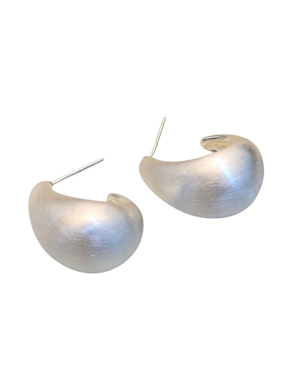Close-up of two brushed silver chunky teardrop earrings with visible stud posts
