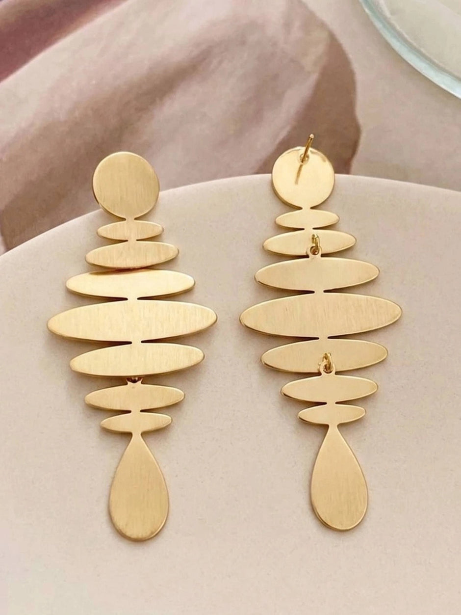 Front and back view of matte gold geometric earrings showing push-back stud post closure on pink surface