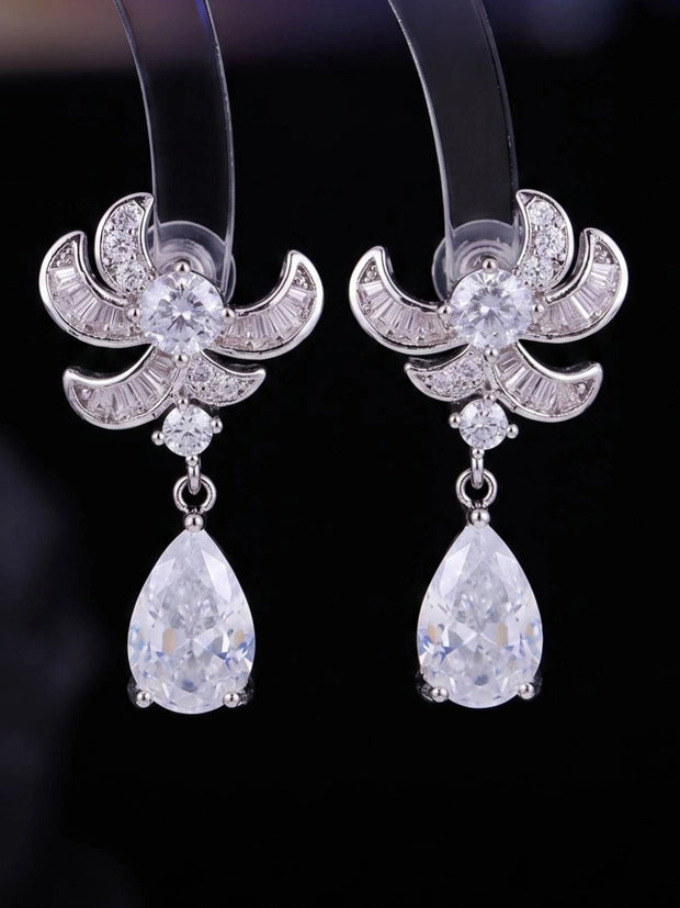 Pair of silver-finish CZ teardrop dangler earrings displayed on a dark background showing full front detail
