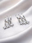 Pair of silver double hoop earrings with three CZ star charms laid on white satin fabric