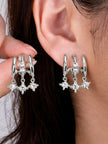 Silver CZ star charm double hoop earrings worn on a model's ear, showing front and back view