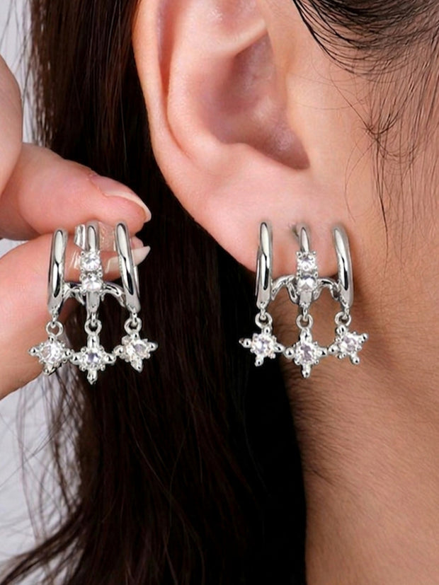 Silver CZ star charm double hoop earrings worn on a model's ear, showing front and back view