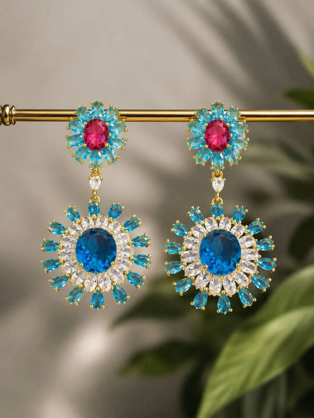 Pair of floral crystal drop earrings hanging on a gold rod showing front detail