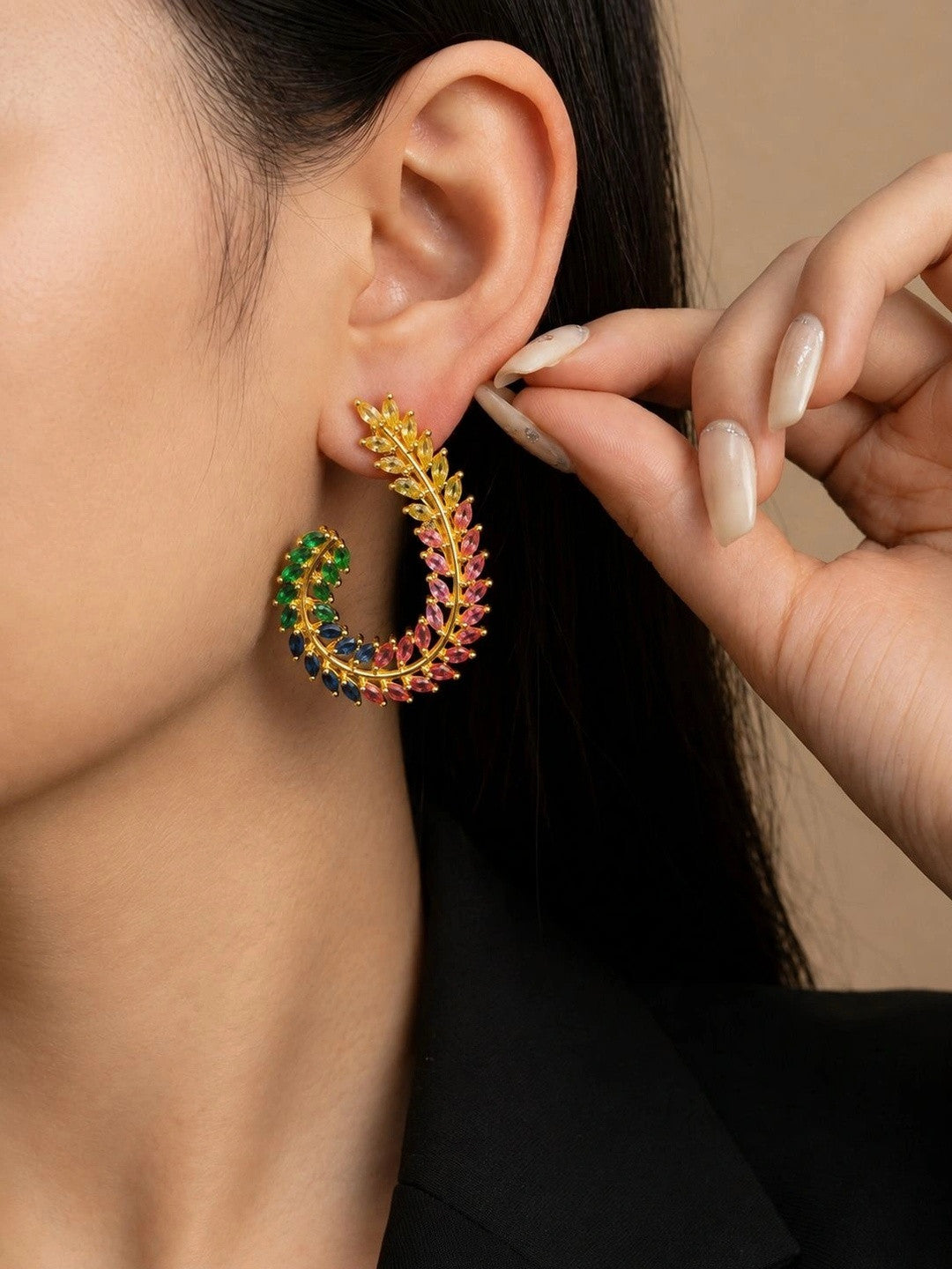 Model wearing one gold-plated multicolour CZ leaf half-hoop earring, hair pulled back to show full crescent shape