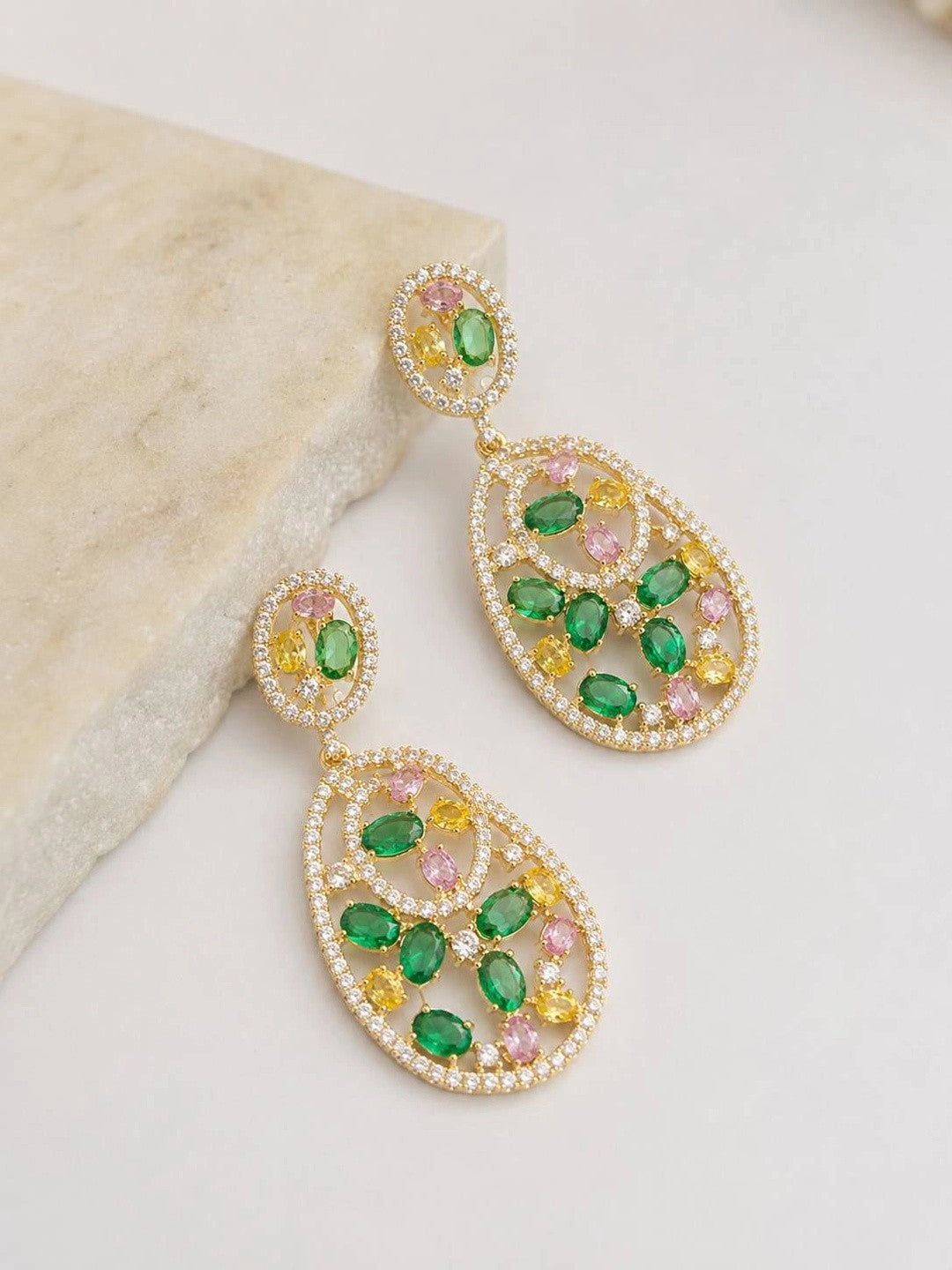 Two gold-plated multicolour CZ teardrop earrings displayed upright against a white marble surface