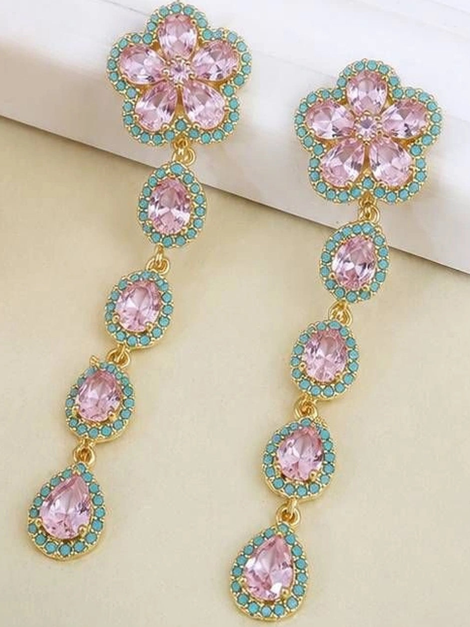 Pair of gold-plated floral drop earrings with pink crystals and turquoise accents on cream surface