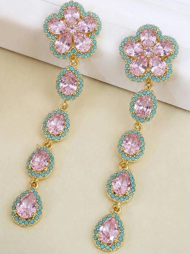Pair of gold-plated floral drop earrings with pink crystals and turquoise accents on cream surface