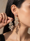 Model wearing long gold-plated pink and teal crystal chandelier drop earrings, side profile close-up