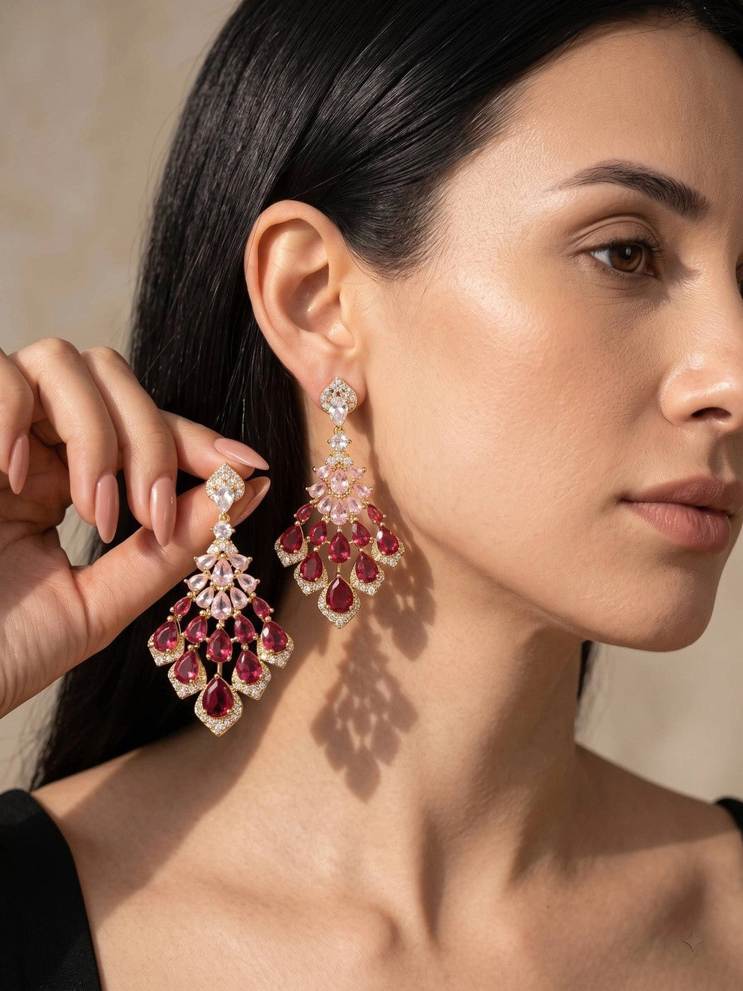 Model wearing gold-plated ruby and pink CZ chandelier drop earrings, side profile view