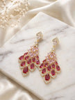 Gold-tone chandelier drop earrings with ruby CZ teardrops displayed on a marble surface