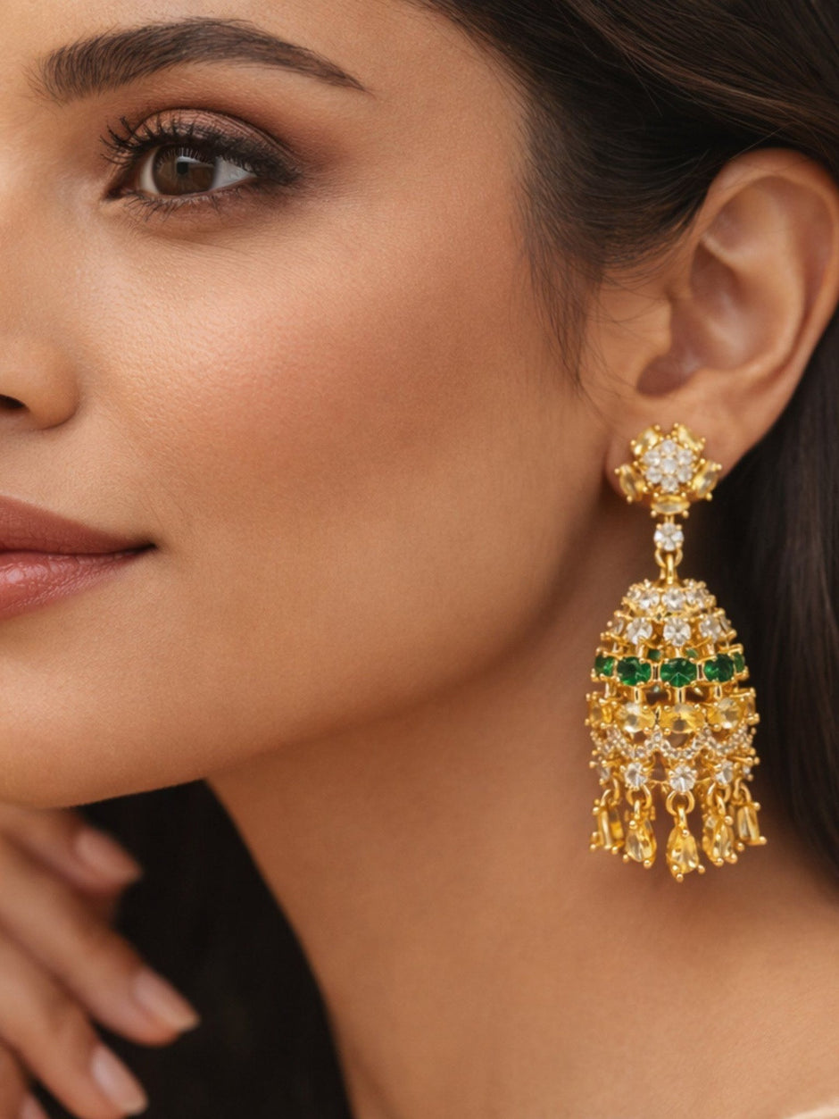 Close-up of gold-plated emerald and white CZ chandelier earring worn on a model showing scale and drape