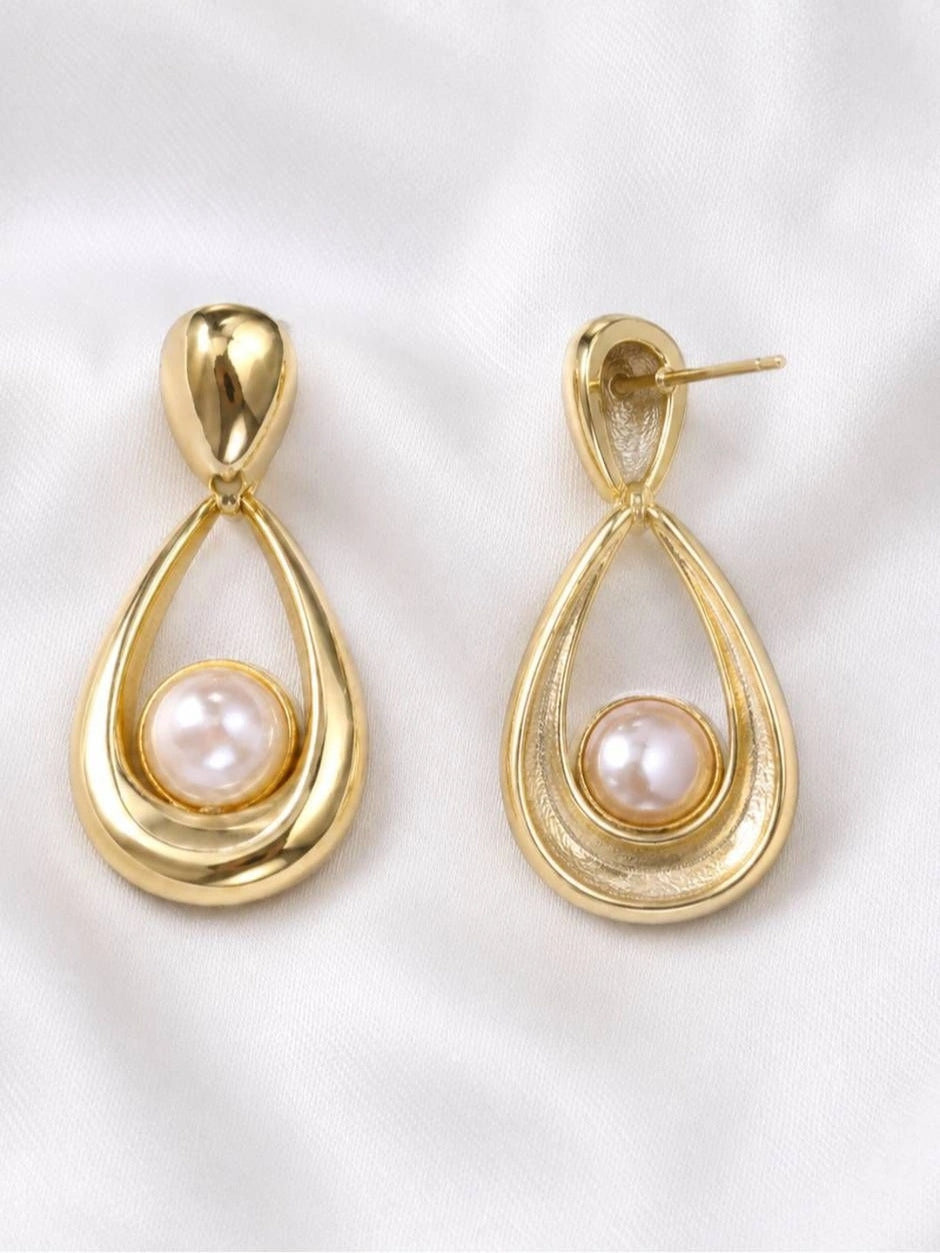 Front and back view of gold pearl drop earrings showing push-back stud post on white satin