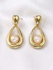 Both gold teardrop pearl drop earrings laid flat side by side on white fabric, front-facing