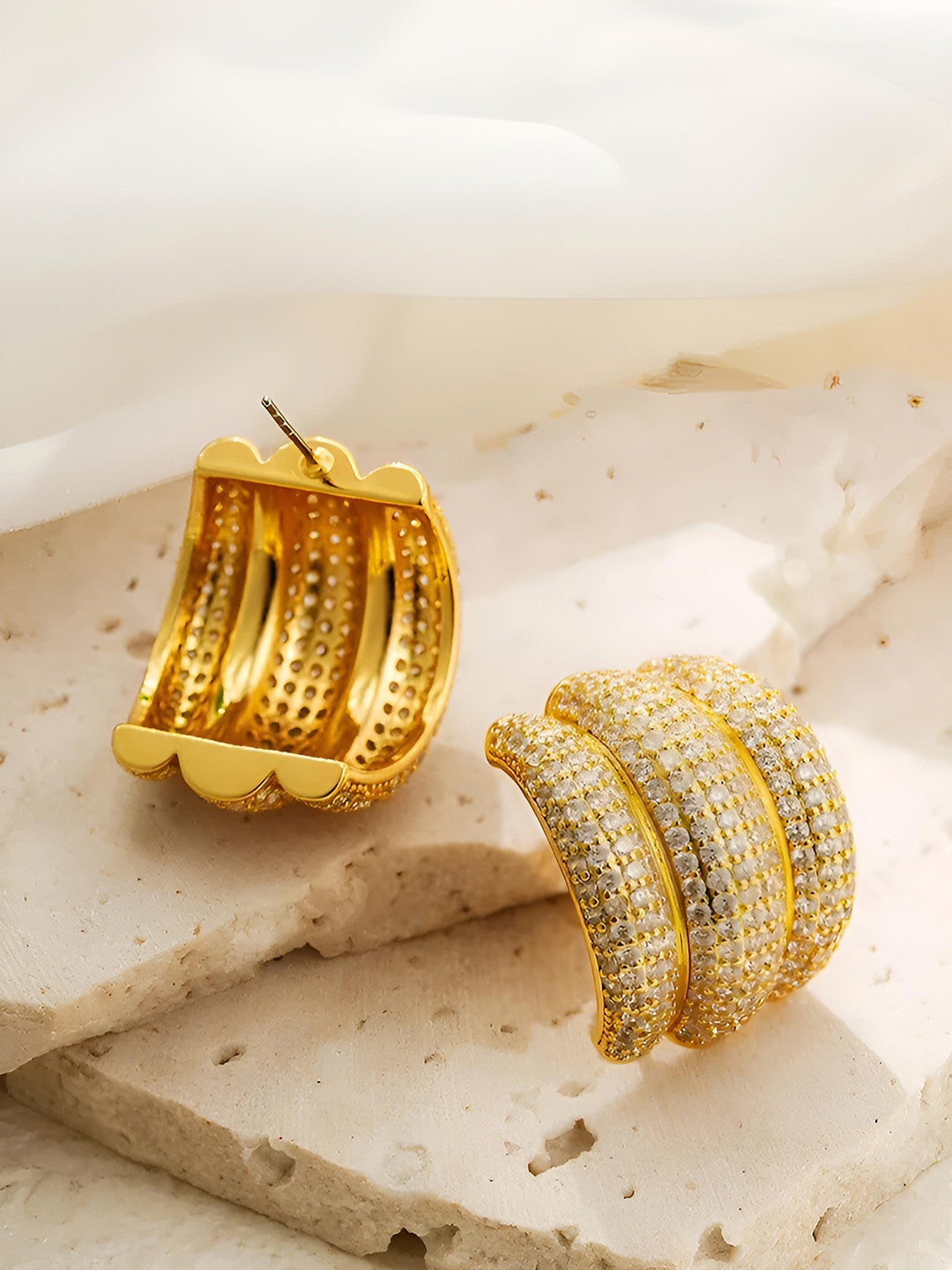 Pair of gold-plated pave cubic zirconia chunky hoops displayed flat on a white background