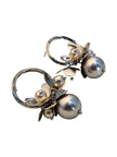Both silver hoop earrings displayed at an angle showing grey and champagne faux pearl cluster detail on white background