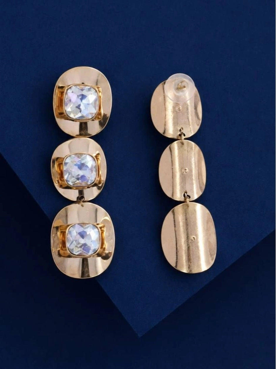 Front and back view of gold-plated three-tier crystal drop earrings against a navy blue background