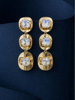 Close-up of gold-plated three-link crystal drop earrings showing faceted stone detail