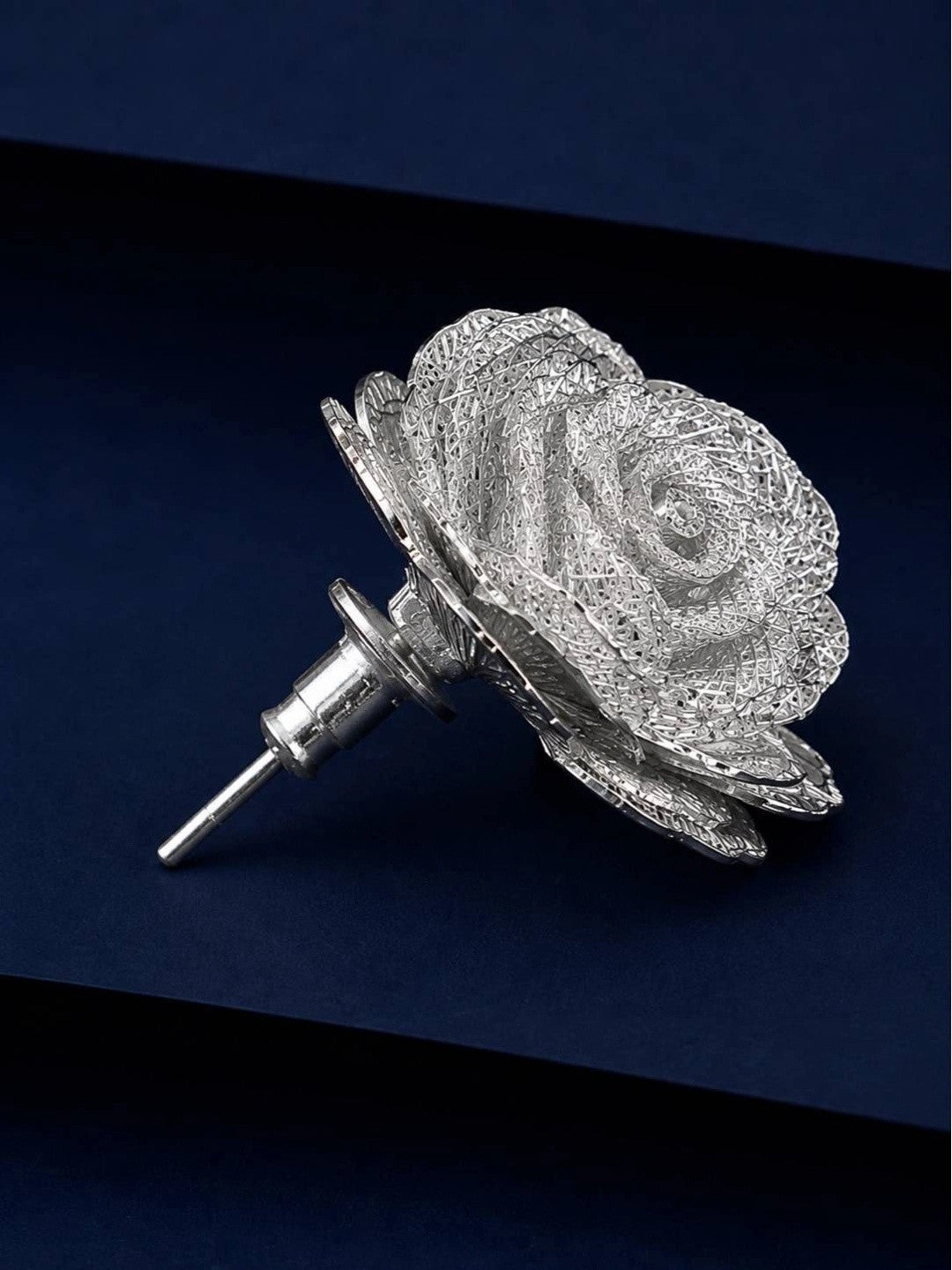 Side view of a single silver rose stud earring showing push-back post and layered petal depth