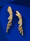 Side and back view of gold bow drop earrings showing clip fitting and CZ tassel drops on blue satin