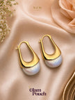 Pair of gold vermeil elongated hoop earrings with ivory pearl drops on peach satin fabric