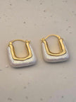 Front-facing view of both baroque pearl hoop earrings laid flat on a marble-effect surface showing full rectangular silhouette