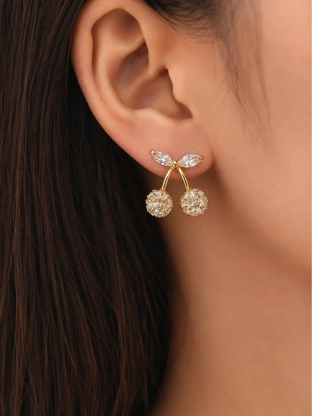 Gold-plated crystal cherry stud earring worn on a model's ear, showing full design with marquise leaf top and two crystal globes