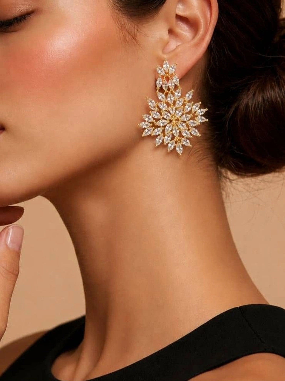 Woman wearing a large gold-plated marquise CZ floral drop earring with a black off-shoulder top