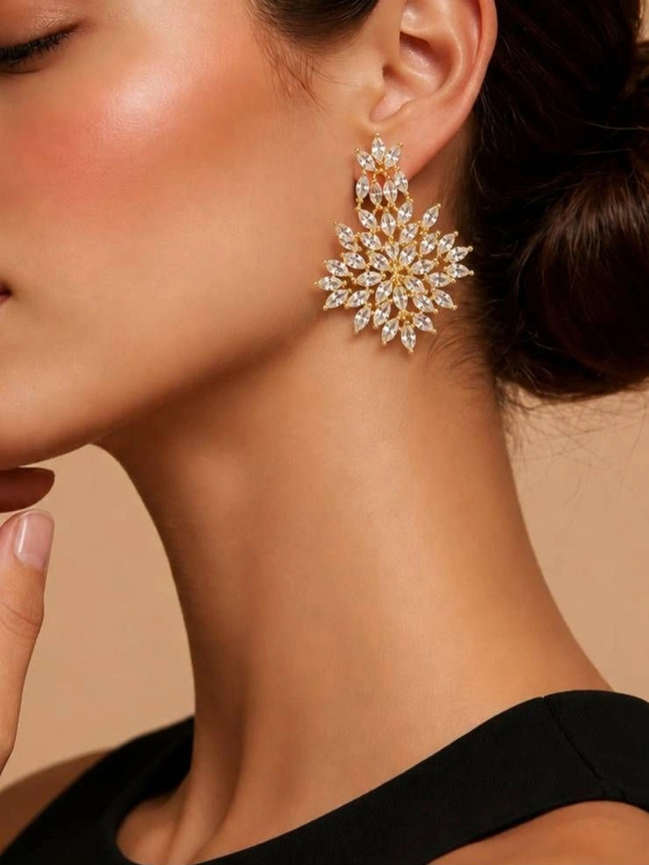 Woman wearing a large gold-plated marquise CZ floral drop earring with a black off-shoulder top