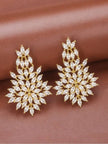 Pair of gold-plated marquise cubic zirconia floral drop earrings laid flat on a mauve surface