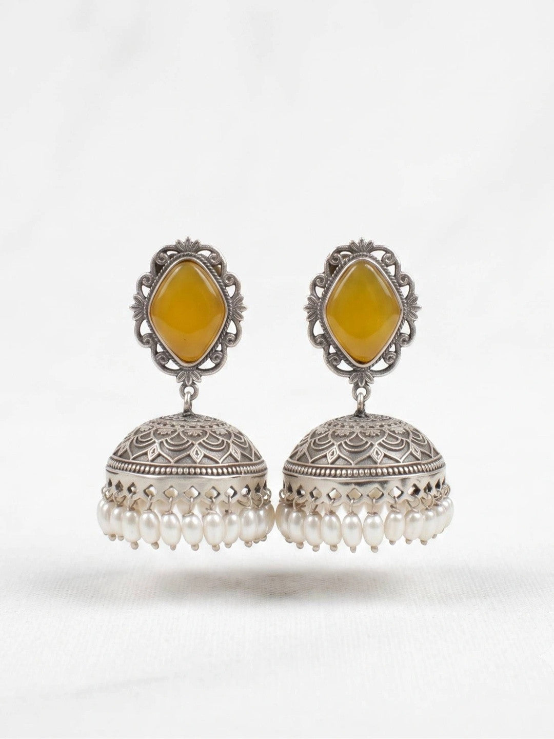 Front view of oxidised silver jhumka earrings with engraved dome and pearl fringe on a white background