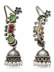 Front and back views of oxidised ear cuff jhumka showing green stones on front and ornate scroll-work detailing on reverse