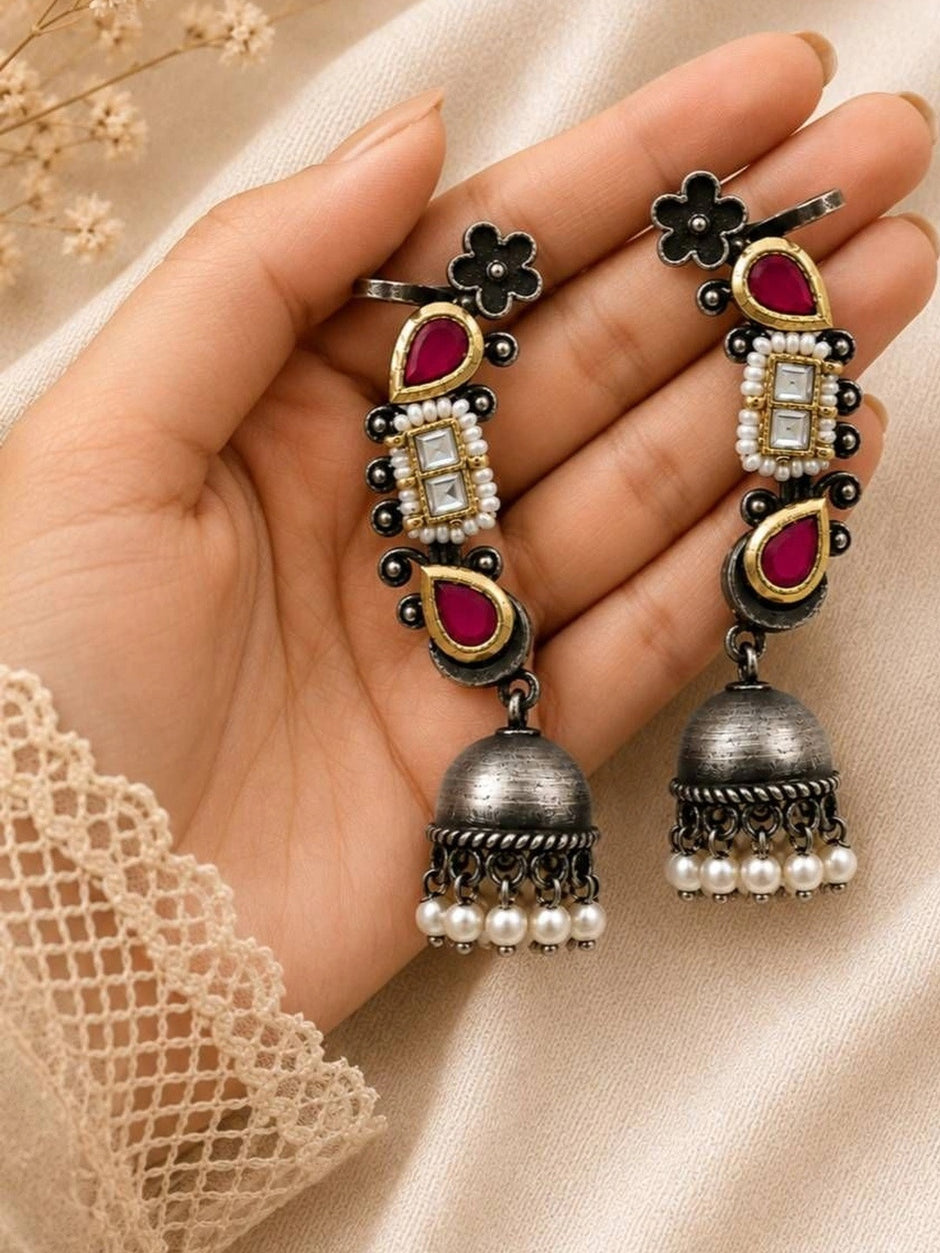 Both oxidised silver Kundan ear cuff jhumkas resting on an open palm showing scale and pearl drop detailing