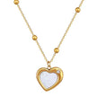 Gold chain necklace with beaded detailing, heart-shaped white enamel pendant, and diamond accent.