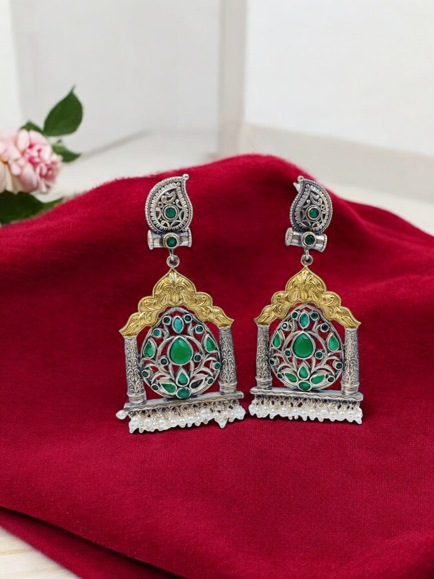 Antique oxidised temple earrings with golden arch, green gemstone floral motif and pearl bead danglers.
