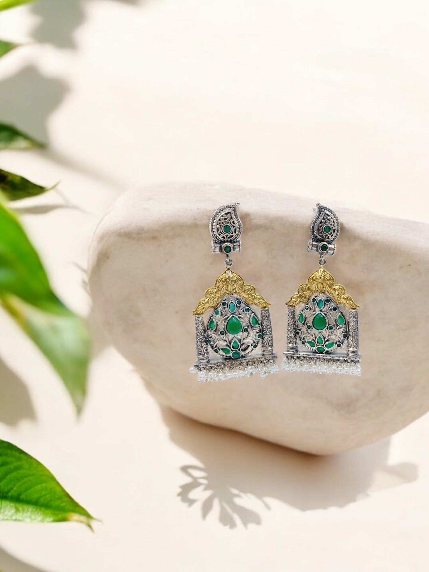 Traditional silver temple earrings with golden arch, green stone floral motifs and pearl drops for ethnic elegance.