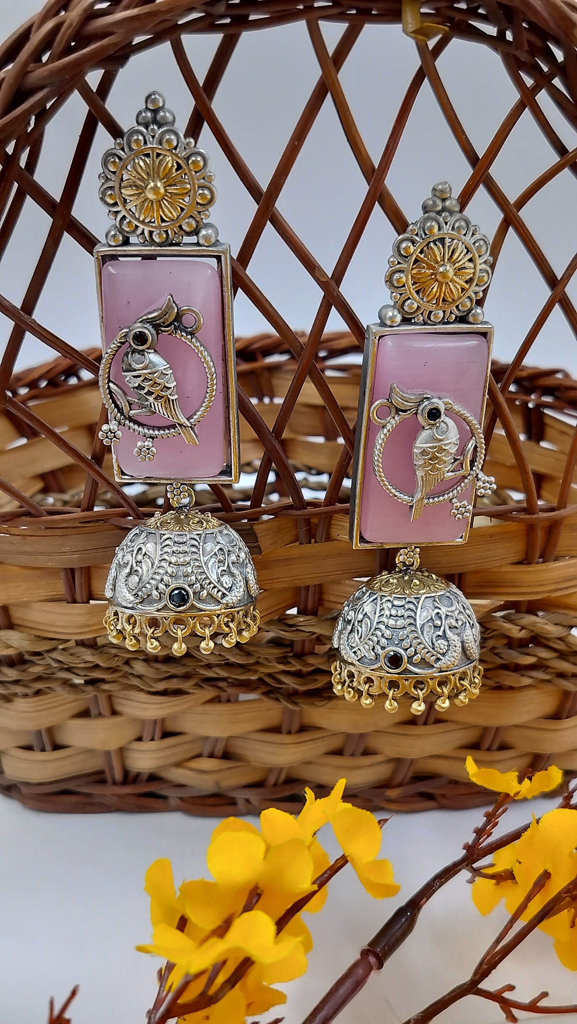 Antique silver jhumkas with pastel pink base & bird motif – timeless elegance in every detail.