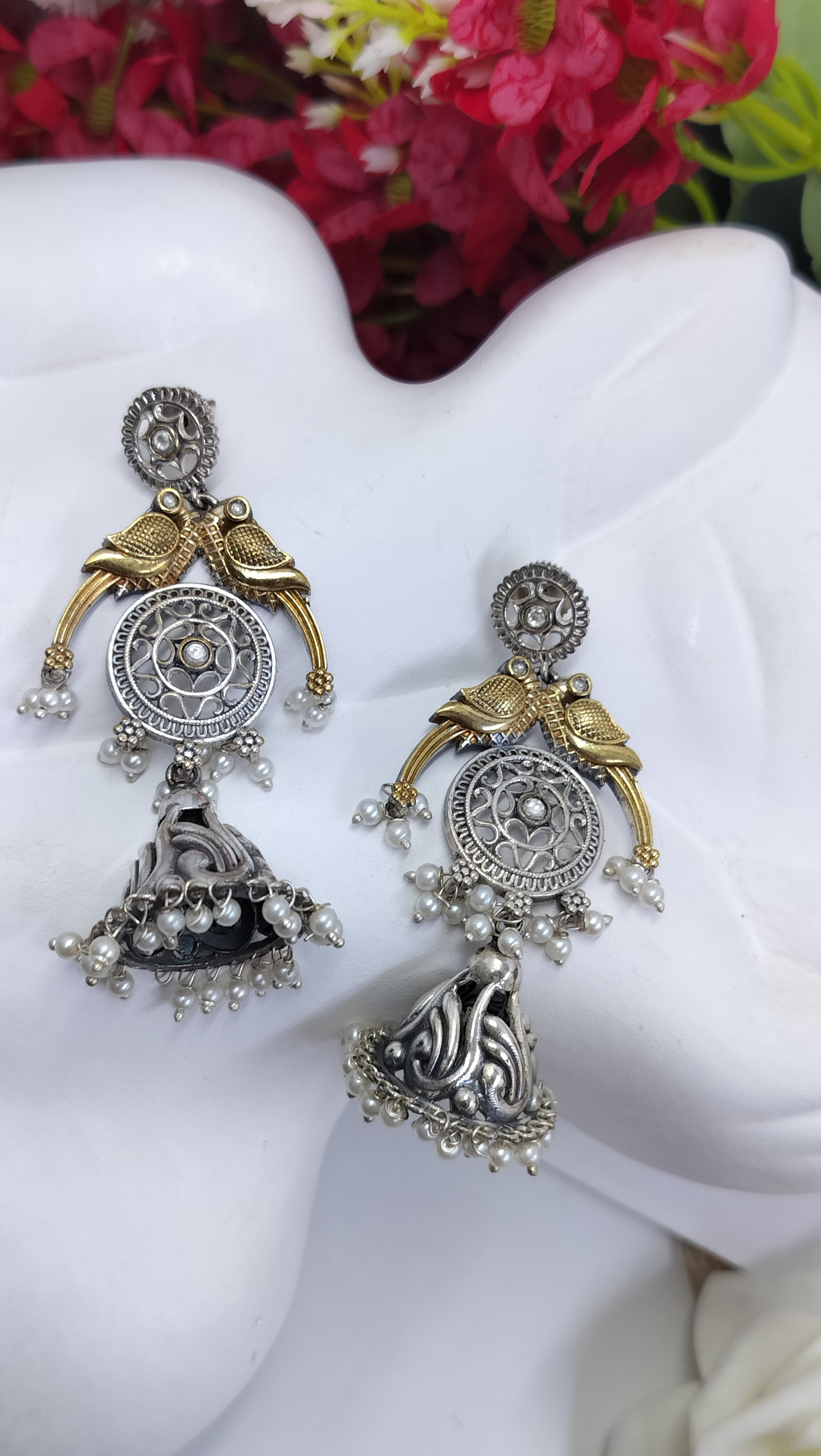 Antique oxidized jhumka earrings with golden bird motif, circular carvings and pearl danglers for ethnic wear.