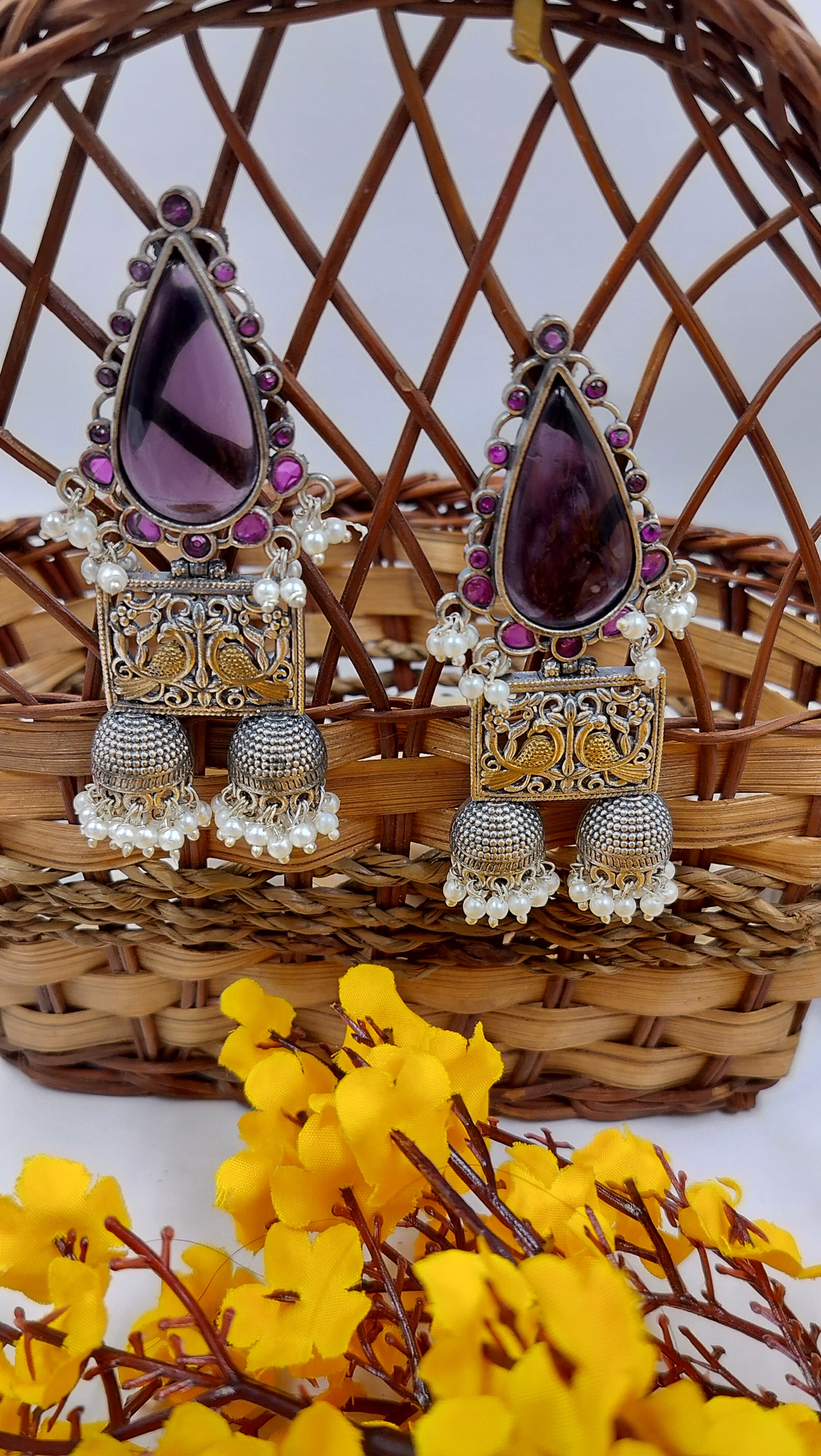 Antique oxidized silver earrings with purple teardrop stone, pink accents, intricate carvings and ghungroo charms.