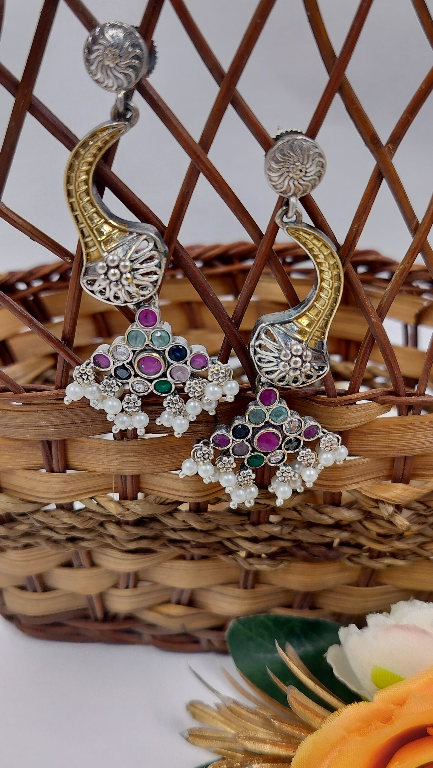 Traditional oxidized silver-plated long earrings, adorned with purple & green stones, delicate pearl drops, and intricate floral detailing – perfect for festive and ethnic wear.