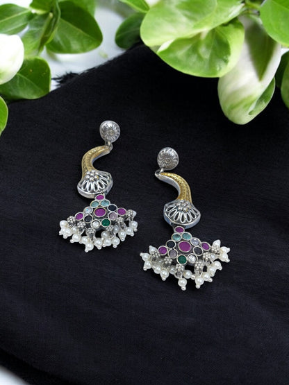 Oxidized silver-plated jhumka earrings with floral motifs, embellished with green & purple stones and pearl beads – a perfect blend of traditional and festive elegance.