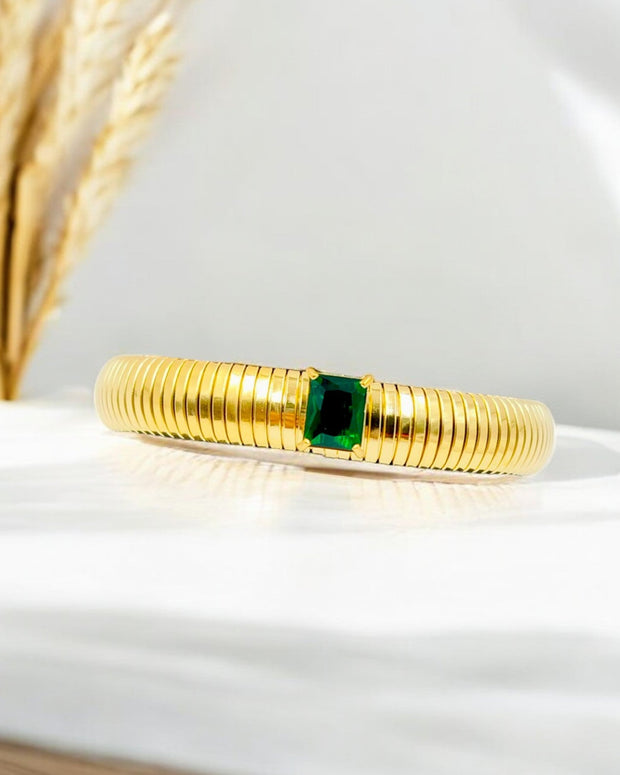 Classic gold plated bangle with a striking emerald-cut green stone centerpiece – a perfect blend of elegance and modern charm.